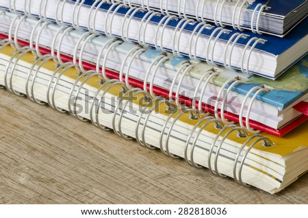 Stack of notebook on wooden background.