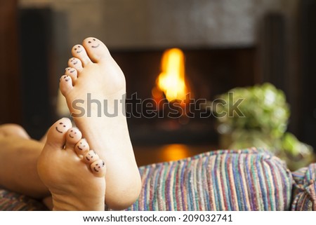 Feet with smiling faces by fireplace