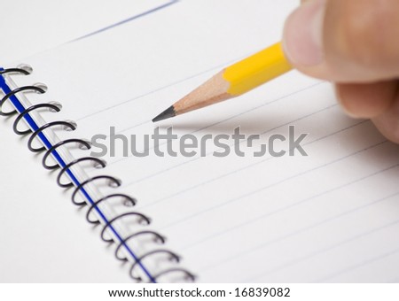 Note pad with pencil being held by a person