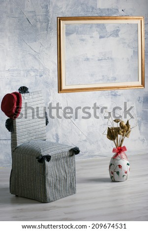 The chair, the vase and the frame/Three objects typical of a retro room.