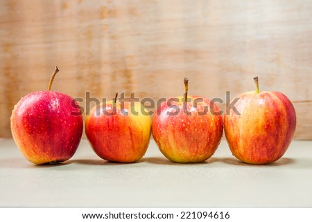 four apples difference colors on wood table.