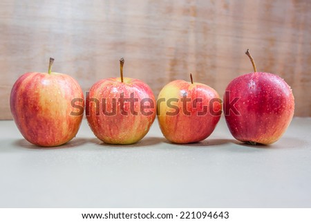 four apples difference colors on wood table.