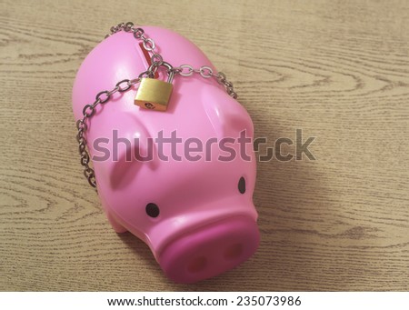 piggy bank with chain lock on wooden background. abstract background for solution to security money saving ,investment ,financial.