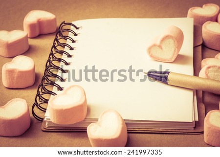 sweet heart shape of marshmallows with note book on wooden background,decoration for love and valentine day concept.
