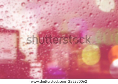 bluured of raindrops on window at night in the city