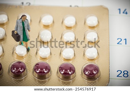 blurred , birth control pills with miniature doctor woman. abstract background to solution of birth control.