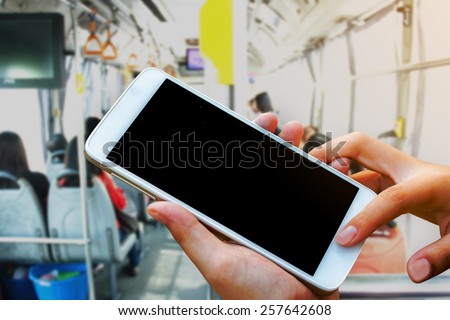 woman hand hold and touch screen smart phone, tablet,cellphone on city metro bus in morning background.