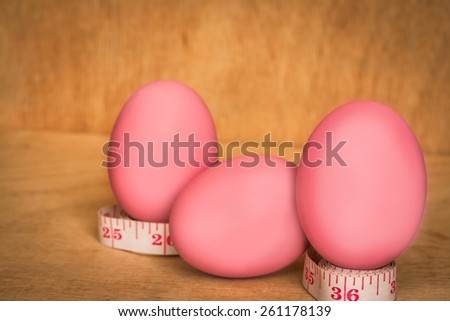 eggs and measure tape on wooden background,abstract background to good food foe diet concept.