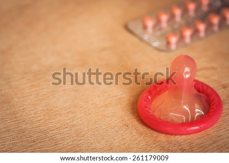 condom and birth control pills on wooden table background.soft and selective focus.