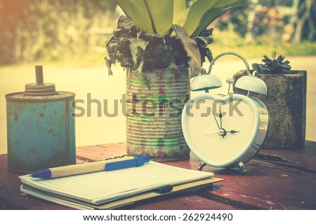 retro clock in garden with notebook and recycle can decorate for tree on coffee brake time..