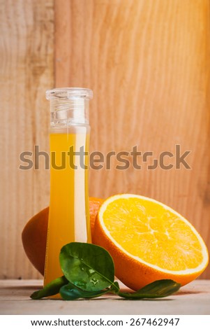 bottle of orange fragrance oil,essential oil with orange cut on wooden floor.