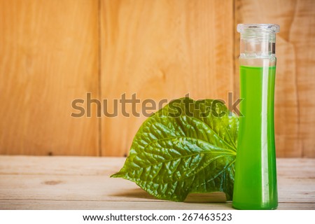 bottle of betel leaf oil extract on wooden floor.