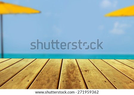 wood terrace on the beach with sun light,clear sky and blue sea.