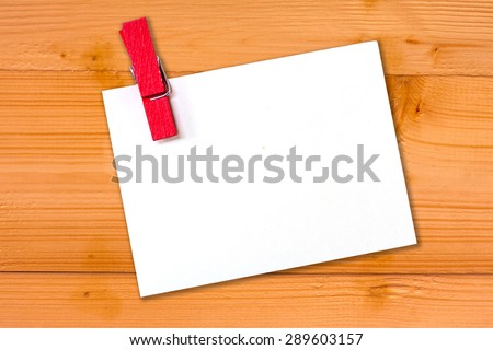 empty white paper with wood clip on wooden background  for text.