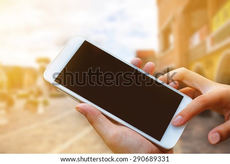 woman hand hold and touch screen smart phone, tablet,cellphone over house or home  for sale background, abstract background for solution of house or  home or property.