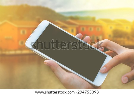 woman hand hold and touch screen smart phone, tablet,cellphone over house or home for sale background, abstract background for solution of house or home or property.