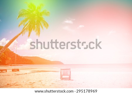 soft focus of coconut tree and beach wooden bed on white sand with beautiful blue sea over clear blue sky. filtered color tone.