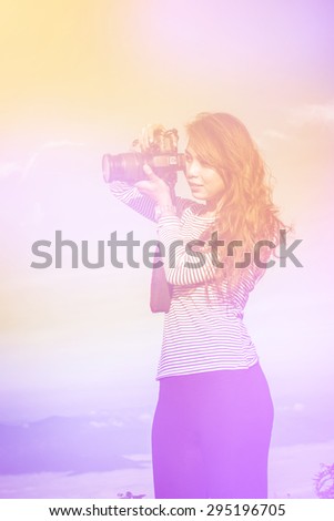 soft focus of asian woman with camera outdoors portrait on day noon, filter colored picture style..