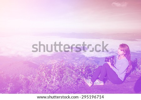 soft focus of asian woman with camera outdoors portrait on day noon, filter colored picture style..