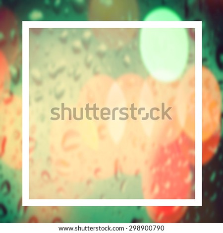 blank design frame. label over blurred bokeh on window with rain drop background,vintage color tone.