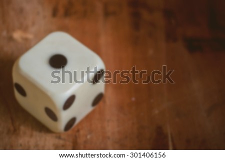 blurred of old dice on wooden table,vintage color tone,abstract background to risk management concept.