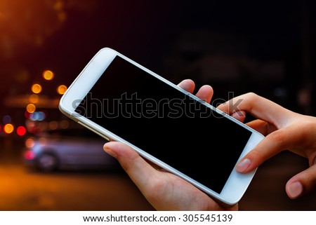 woman hand hold and touch screen smart phone, tablet,cellphone on city traffic accident in dark night background.