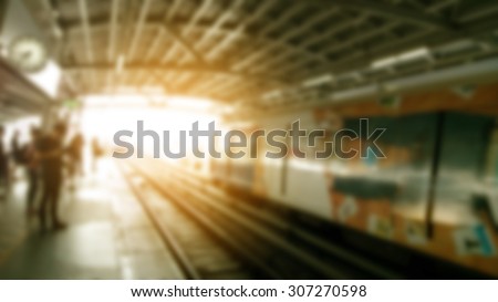 blurred metro station with people in sunset.
