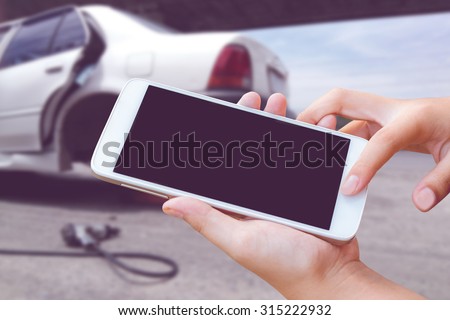 woman hand hold and touch screen smart phone, tablet,cellphone on city traffic accident on day noon background.