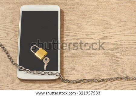 chain lock with smart phone on wooden background. abstract background for solution to security smart phone form not owner.