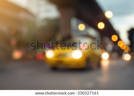 blurred photo of yellow taxi on the road with bokeh background of city street night light.