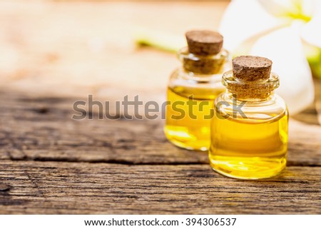 bottle of aroma essential oil or spa or natural fragrance oil with dry flower on wooden table, spa or alternative meditation aroma concept.