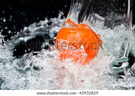 Orange and splash water over black background