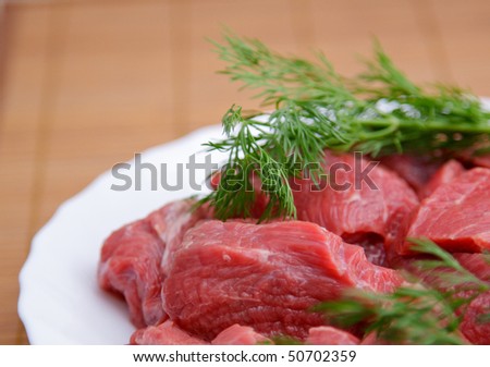 Red meat on white plate and bamboo napkin