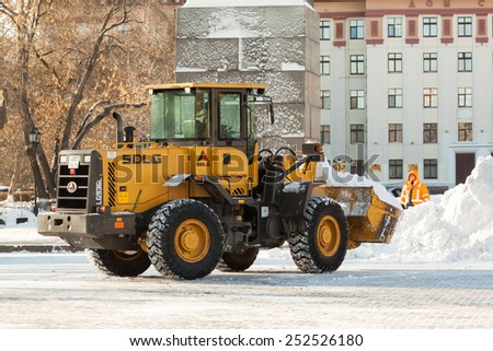 Tyumen, Russia - February 12, 2015: Clearing the snow near the building of Administration of the Tyumen region. Neighborhood streets Republic.