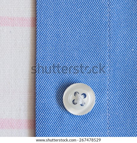 Strap shirt with a button close-up on white cotton fabric