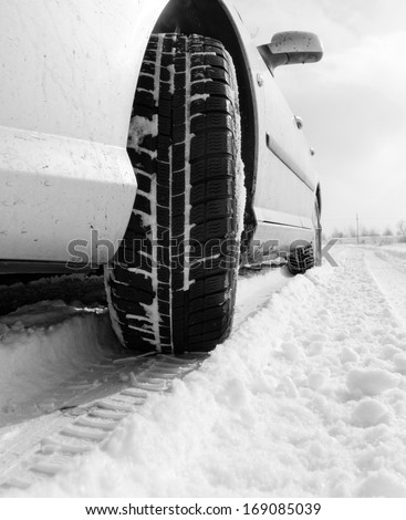 Close up of a cars tires on a snowy road