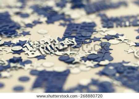 Blue happy birthday confetti pieces - macro photo