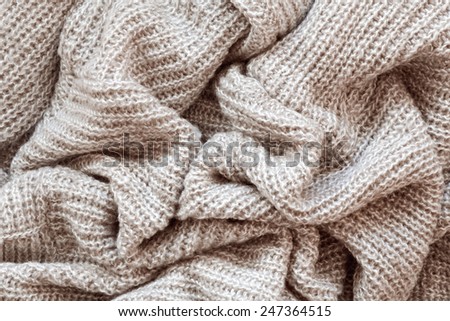 Closeup macro texture of knitted wool fabric, clothing background with wrinkles and folds