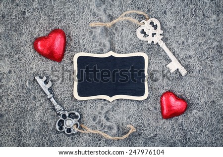 Closeup macro texture of knitted wool gray shawl with two red hearts, Victorian keys and wooden plate board plaque with copy space for text, Valentine holiday card, love concept