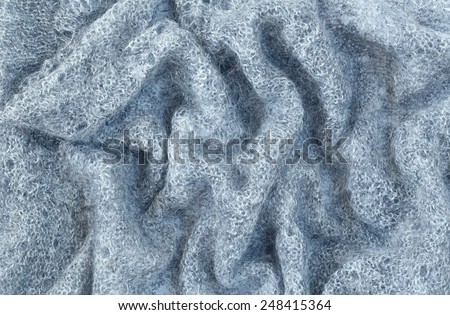 Closeup macro texture of knitted wool fabric, grey shawl, clothing background with wrinkles and folds, russian old style