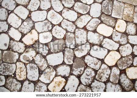 light stones and pebbles on a gray wall pavement path, background, texture