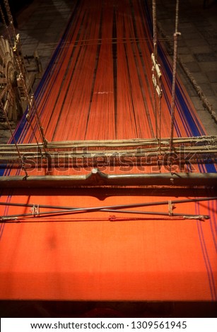 Close up of old, classic Indian hand loom. Indian ethnic garment- saree is being woven on traditional handloom machine.