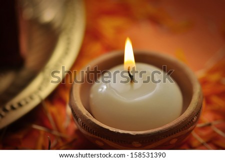 A close up of a candle in an earthen candle-holder