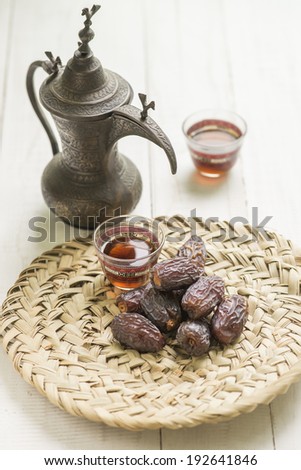 Dates displayed on palm - platter with traditional coffee set