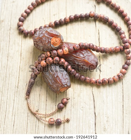Close up of ripped dates with islamic prayer beads