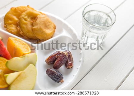 Dates with fruits and fried snacks. Food to break fast during holy month of Ramadan.