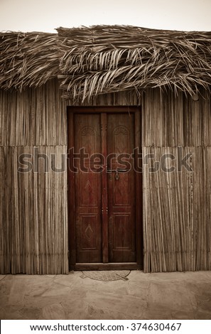 Entrance of traditional islamic home. Wall and roof cladded with natural dry palm leaves.