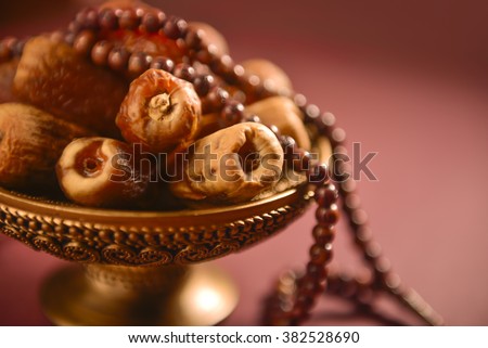 Religious food and objects. Close up of arabic dates and rosary.