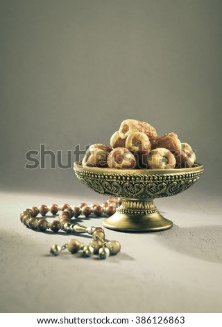 Vintage bowl of dates. Dates in a bowl and islamic prayer beads.