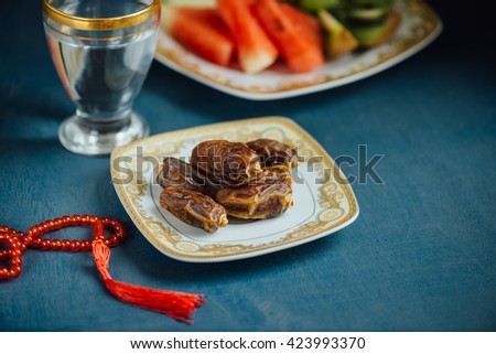 Sweet dates, glass of drinking water and fresh sliced fruits. A healthy food for breaking fast during holy month of Ramadan.